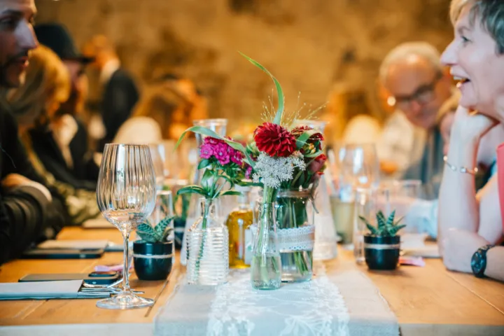Gäste am Tisch, Blumen in Glasvasen